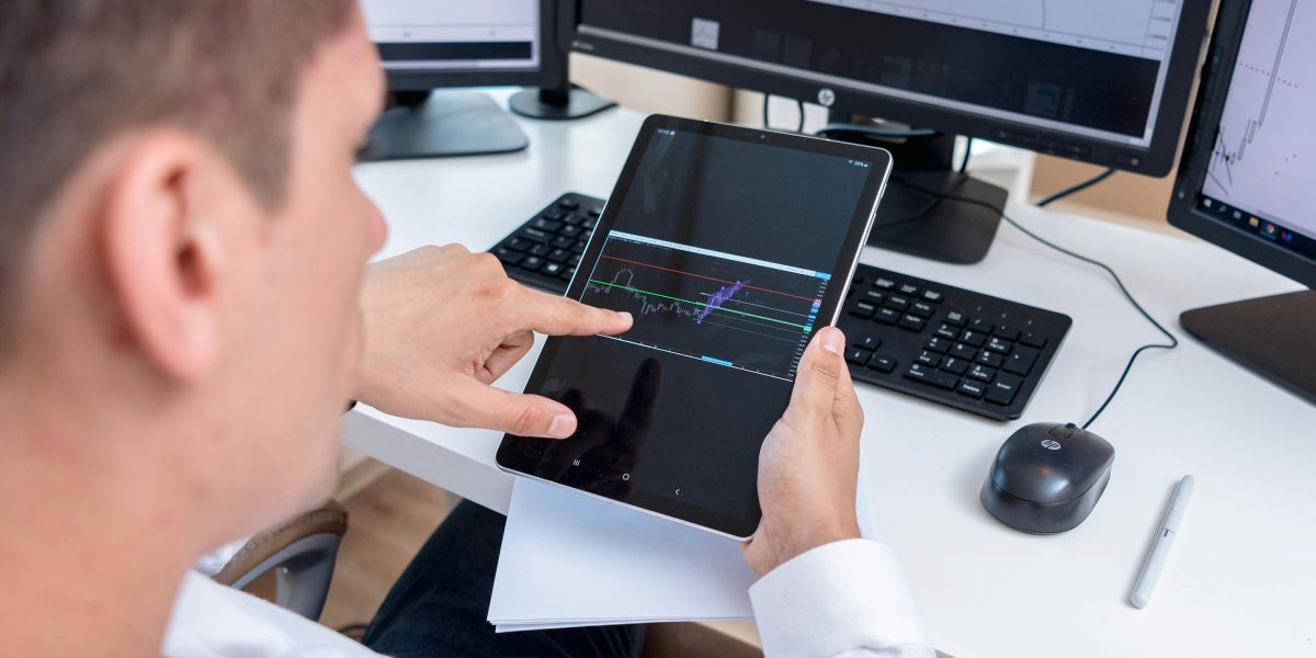 A professional meticulously examining financial market data, reflecting investment focus.
