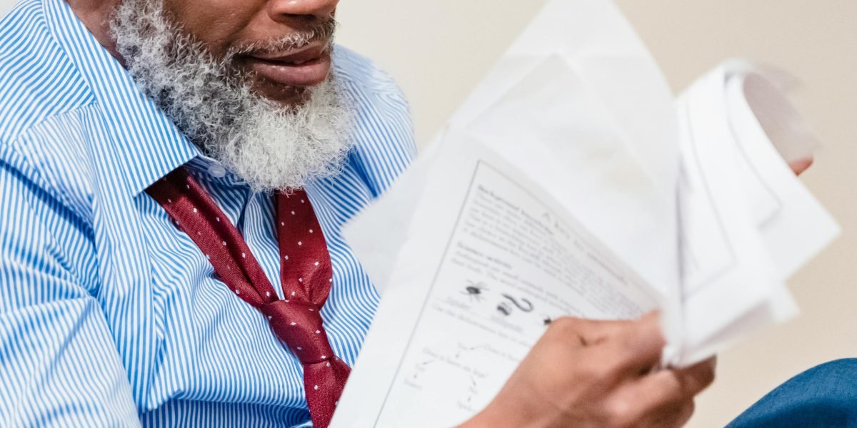 An individual thoughtfully reviewing documents, grappling with complex data.