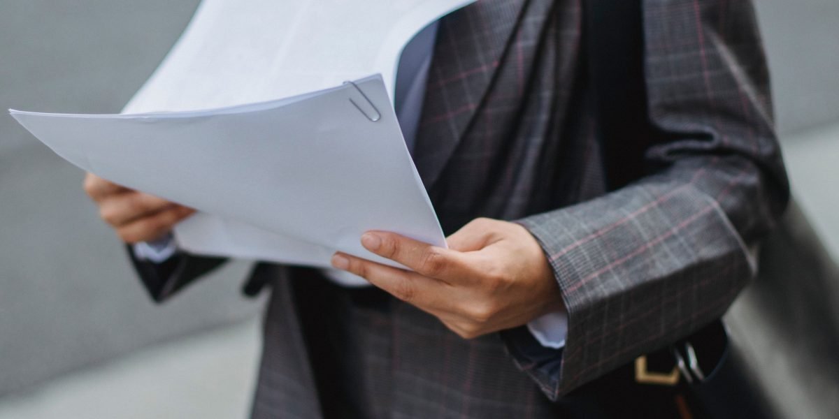 A professional meticulously reviewing detailed financial documents to understand company fundamentals.