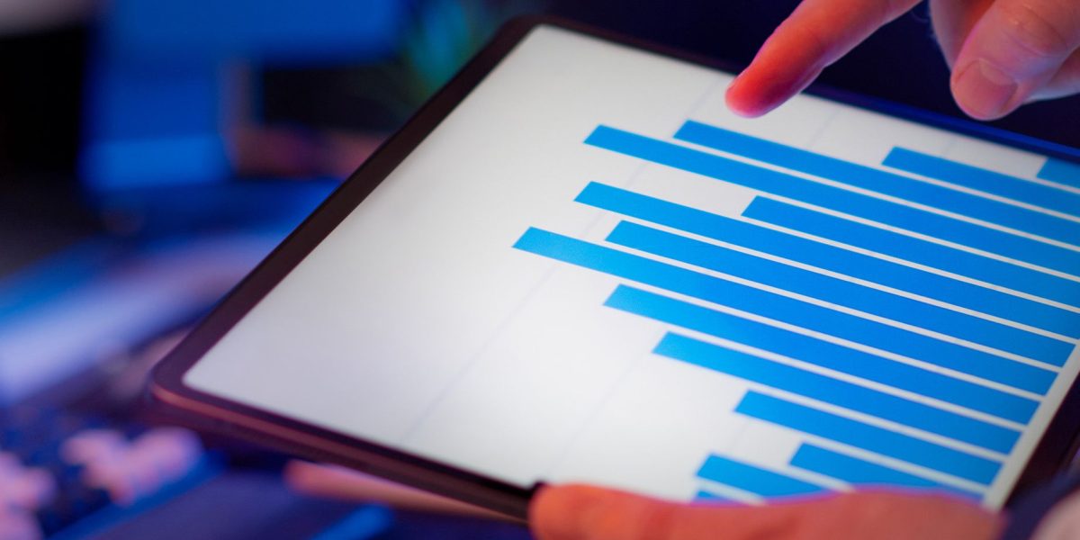 An individual focused on a tablet, actively researching different investment strategies for market exposure.
