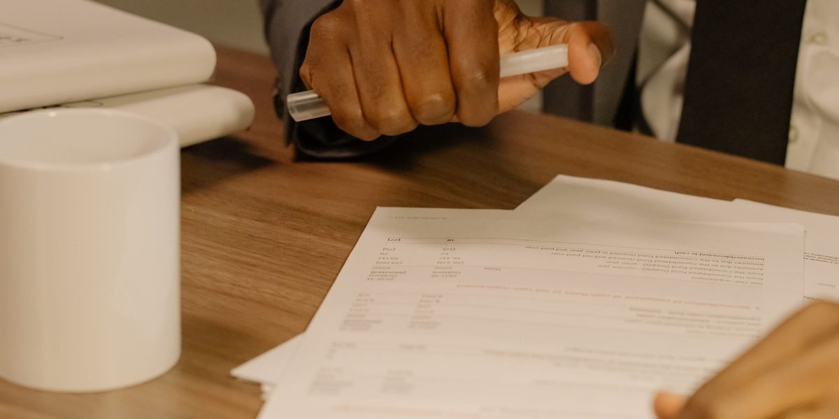 A person intently examines financial charts and reports, symbolizing the process of valuation analysis for a stock.