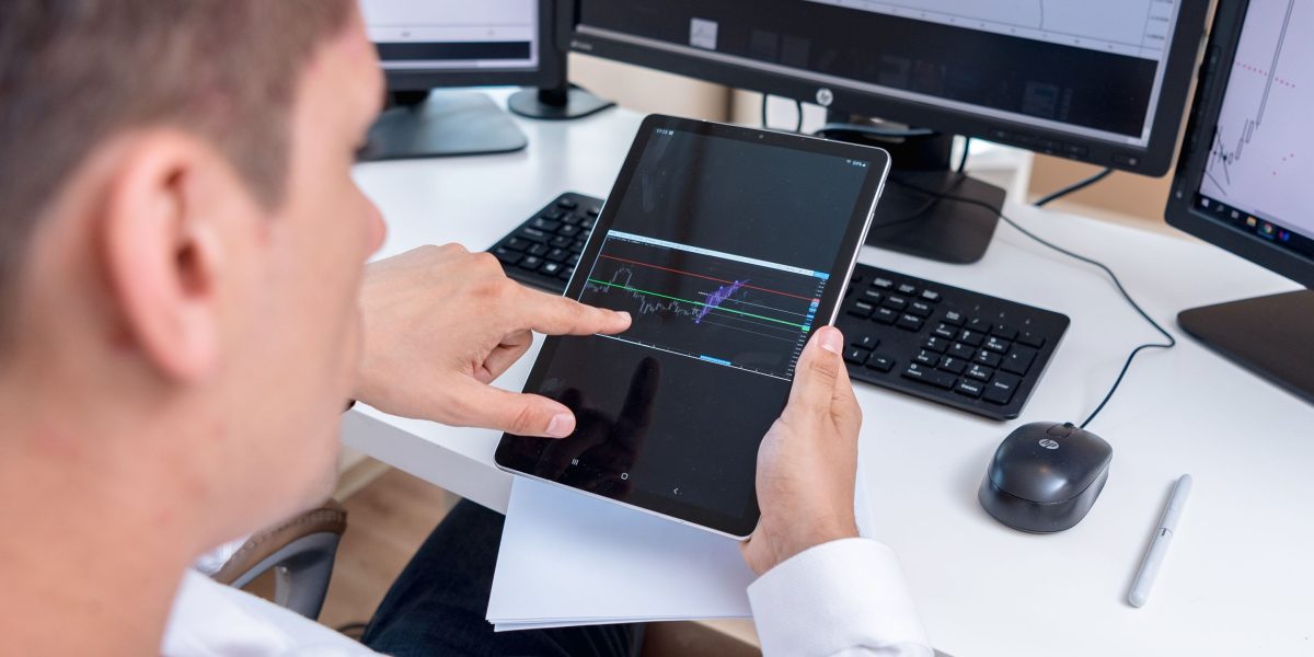 A focused trader intently analyzing multiple screens, looking for early market signals.