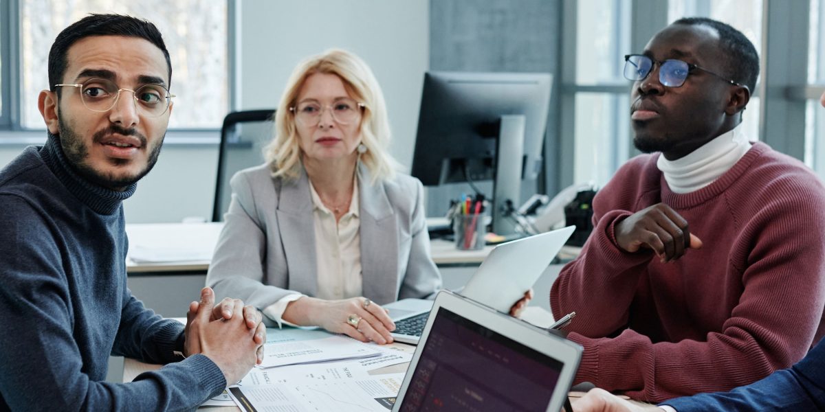 A team of professionals in a boardroom discussing complex regulatory and environmental challenges, using charts or documents.