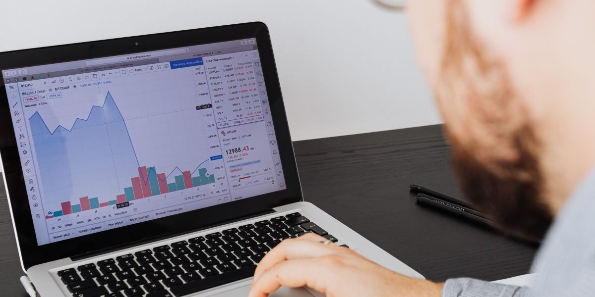 An individual thoughtfully analyzes various data points, symbolizing the process of combining qualitative sentiment with quantitative financial metrics.