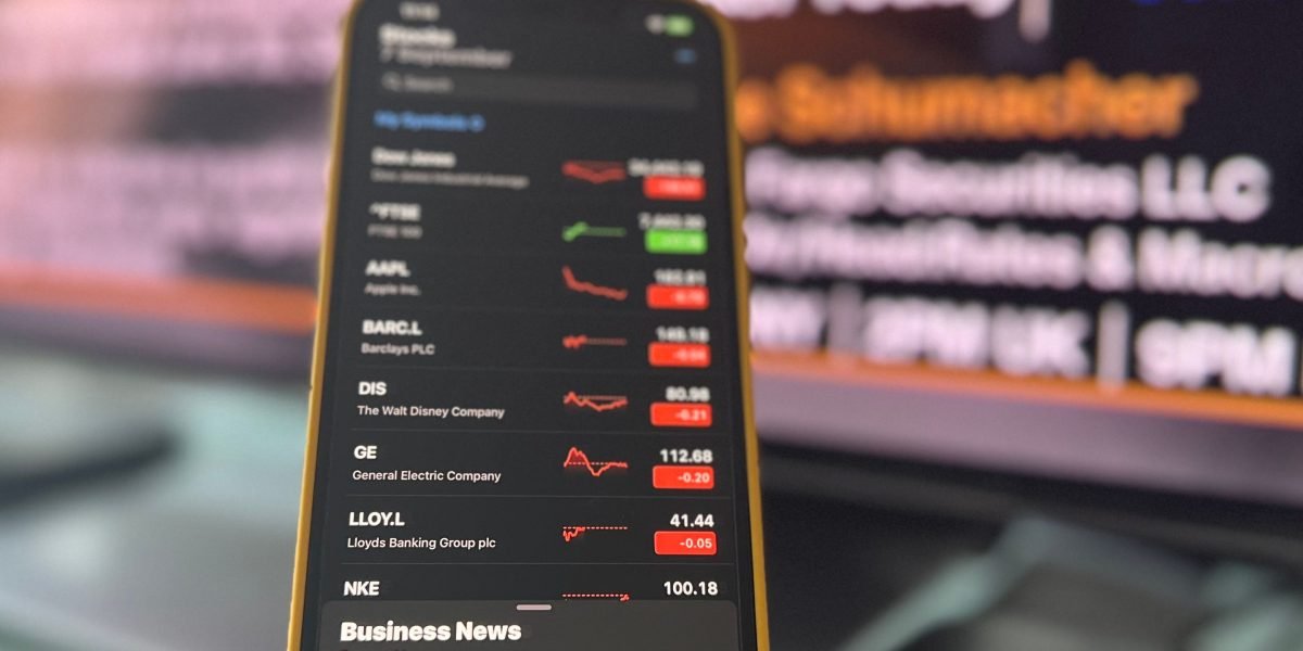 An individual reacting intently to market news on their phone, capturing the immediate emotional response often seen in retail trading communities.