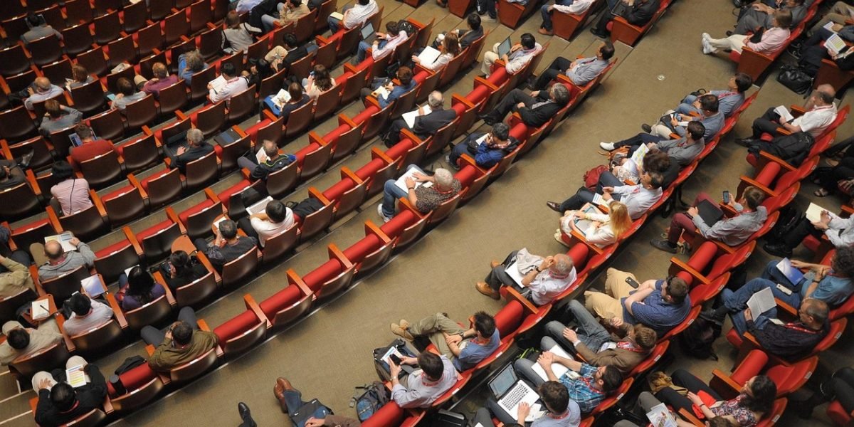 Professionals engage in discussions at a finance conference, spreading key market insights.
