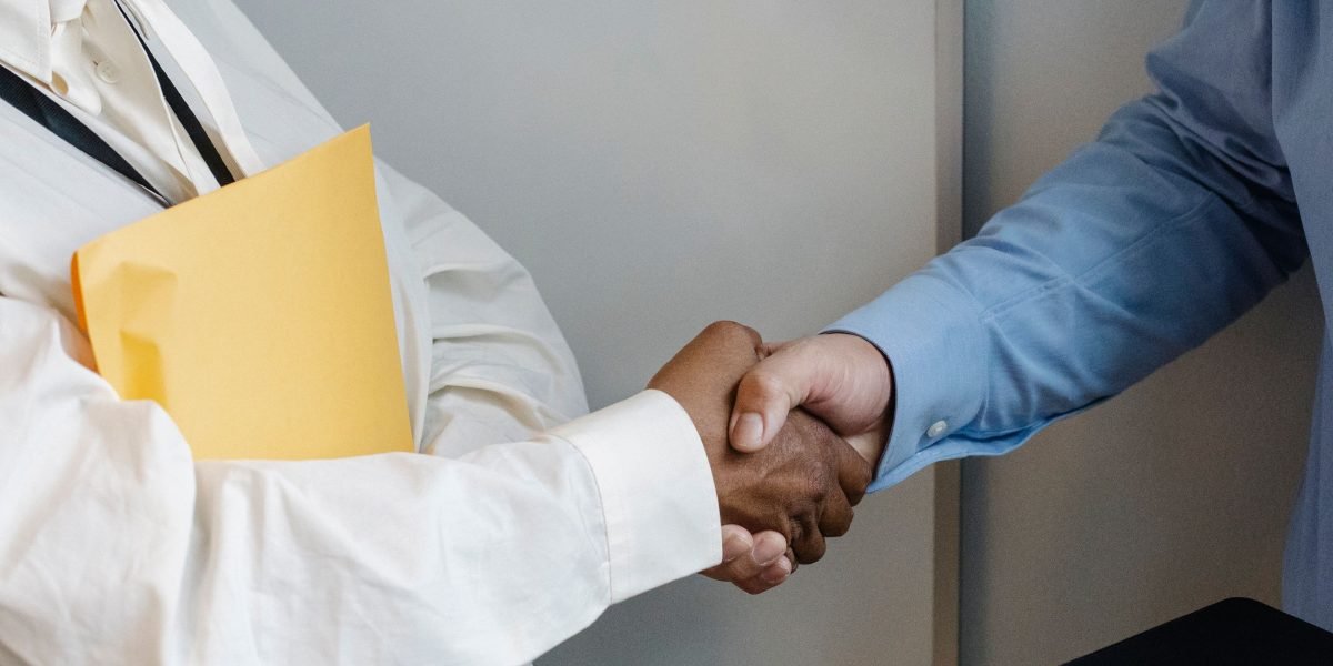 Business partners solidify their collaboration with a handshake, symbolizing the strategic alliances crucial for AI innovation.