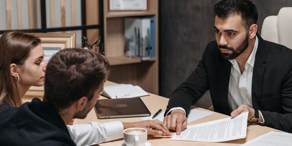 Professionals meticulously reviewing complex legal and regulatory documents, representing the compliance challenges faced by fintech companies.