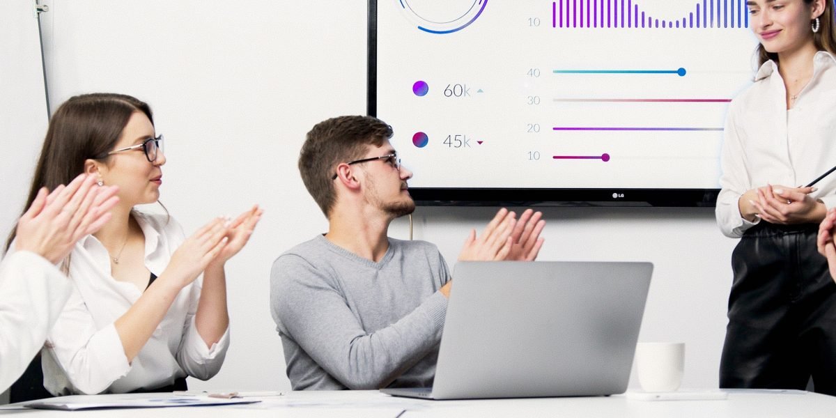 A team of professionals collaborating and strategizing around a whiteboard in a modern office environment.